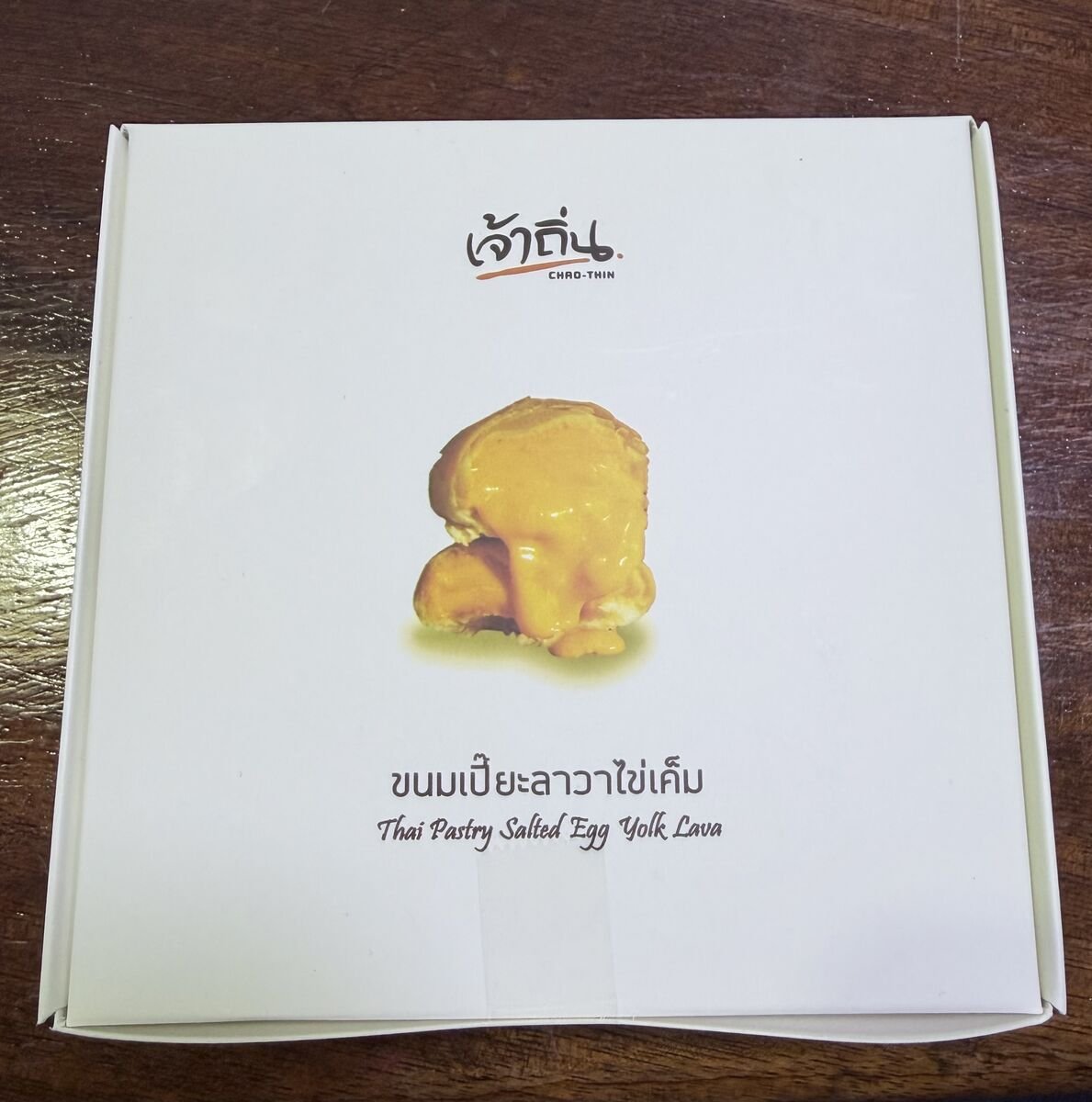 The boxed Thai pastry — ขนมเปี๊ยะลาวาไข่เค็ม, 'Thai Pastry Salted Egg Yolk Lava' — a flaky mooncake-style pastry, sold by the box to take home.
